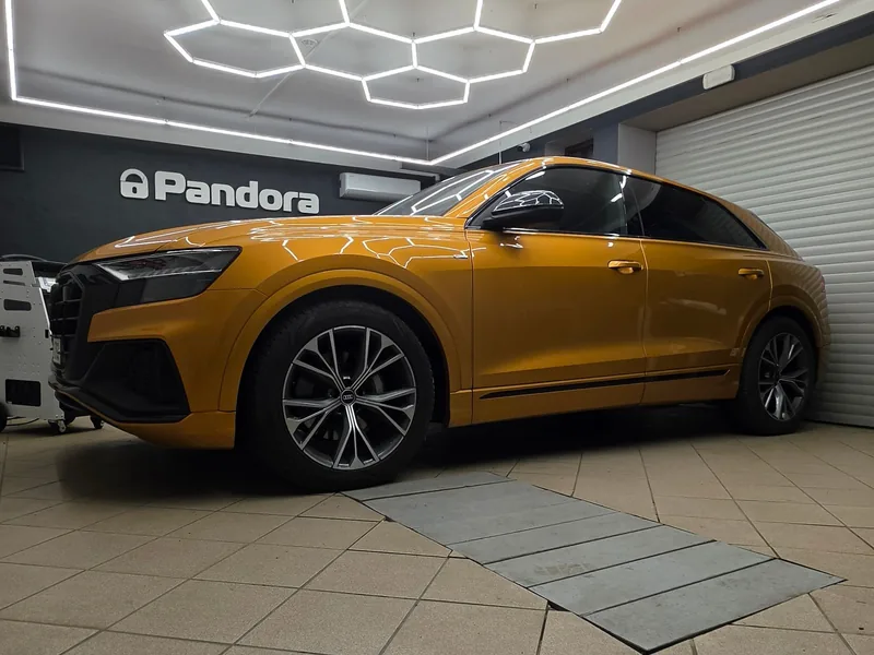 Zlatá Audi Q8 z předního bočního pohledu v dílně ASBT.
