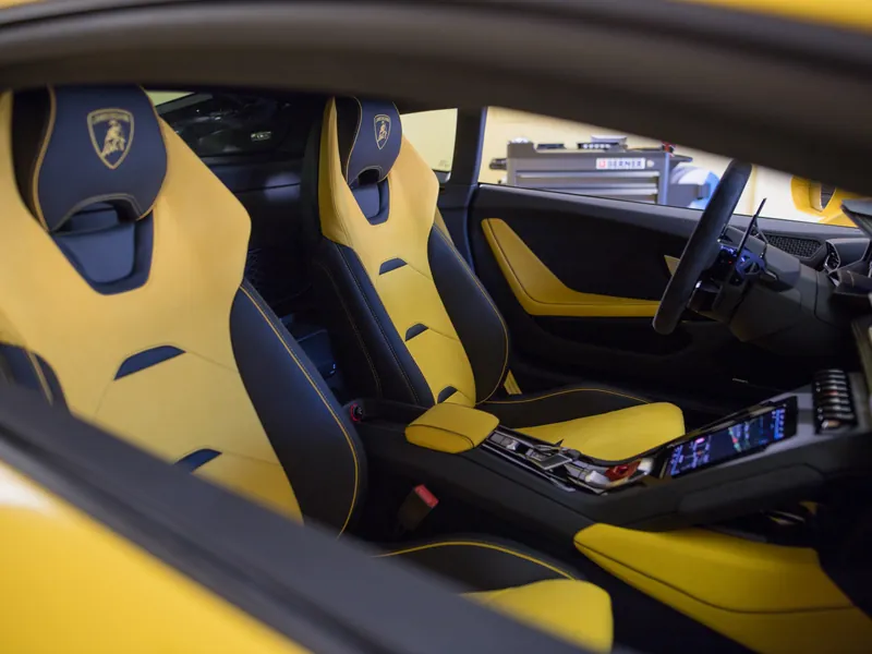 Žlutočerný interiér Lamborghini Huracán s díly v klavírním laku