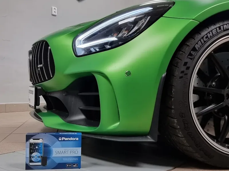 Detail předního světlometu a kola zeleného Mercedesu-AMG GT R